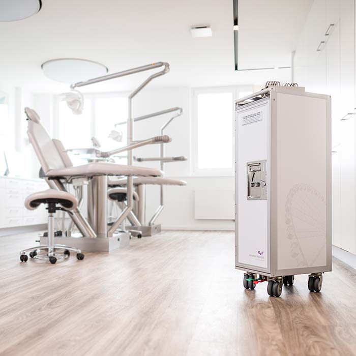 Weiße Behandlungsstühle und ein Flugzeugtrolley mit medizinischem Equipment in steril aussehendem Praxiszimmer