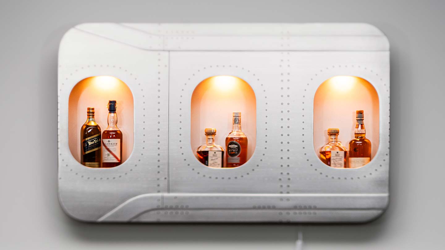 Beleuchtete Wandbar aus echten Flugzeugfenstern, die optimal zum Industrial Style passt